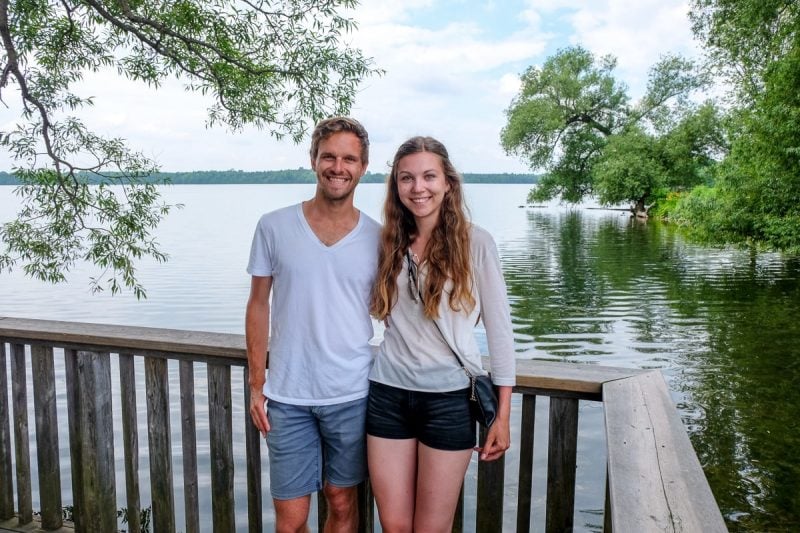 guy and girl wearing white standing in front of lake in ontario away travel blog