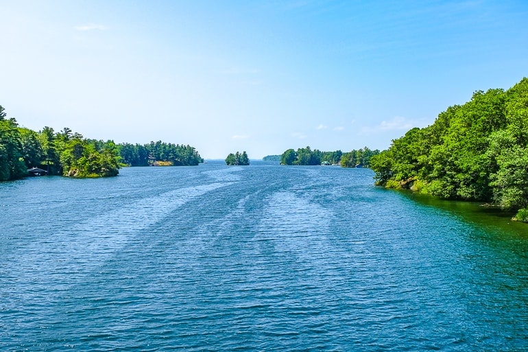 blue waterway through green islands  with blue sky above.