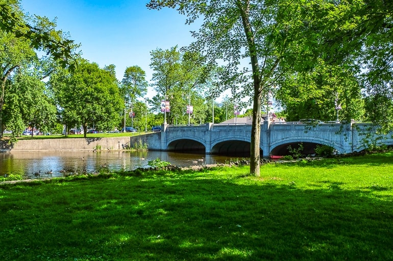 bridge with river under and green park in front.