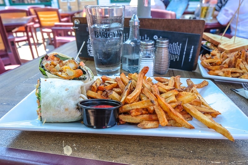 plate on table with fries and a wrap at pub.